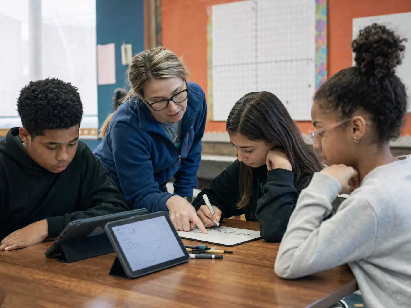 Students working through a digital math lesson with a teacher